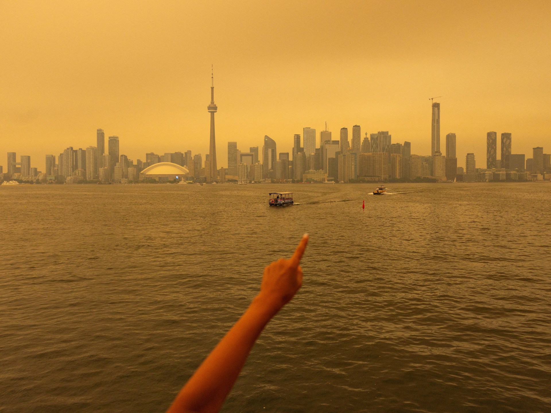 Toronto skyline shrouded in orange wildfire smoke drifting south from Ontario