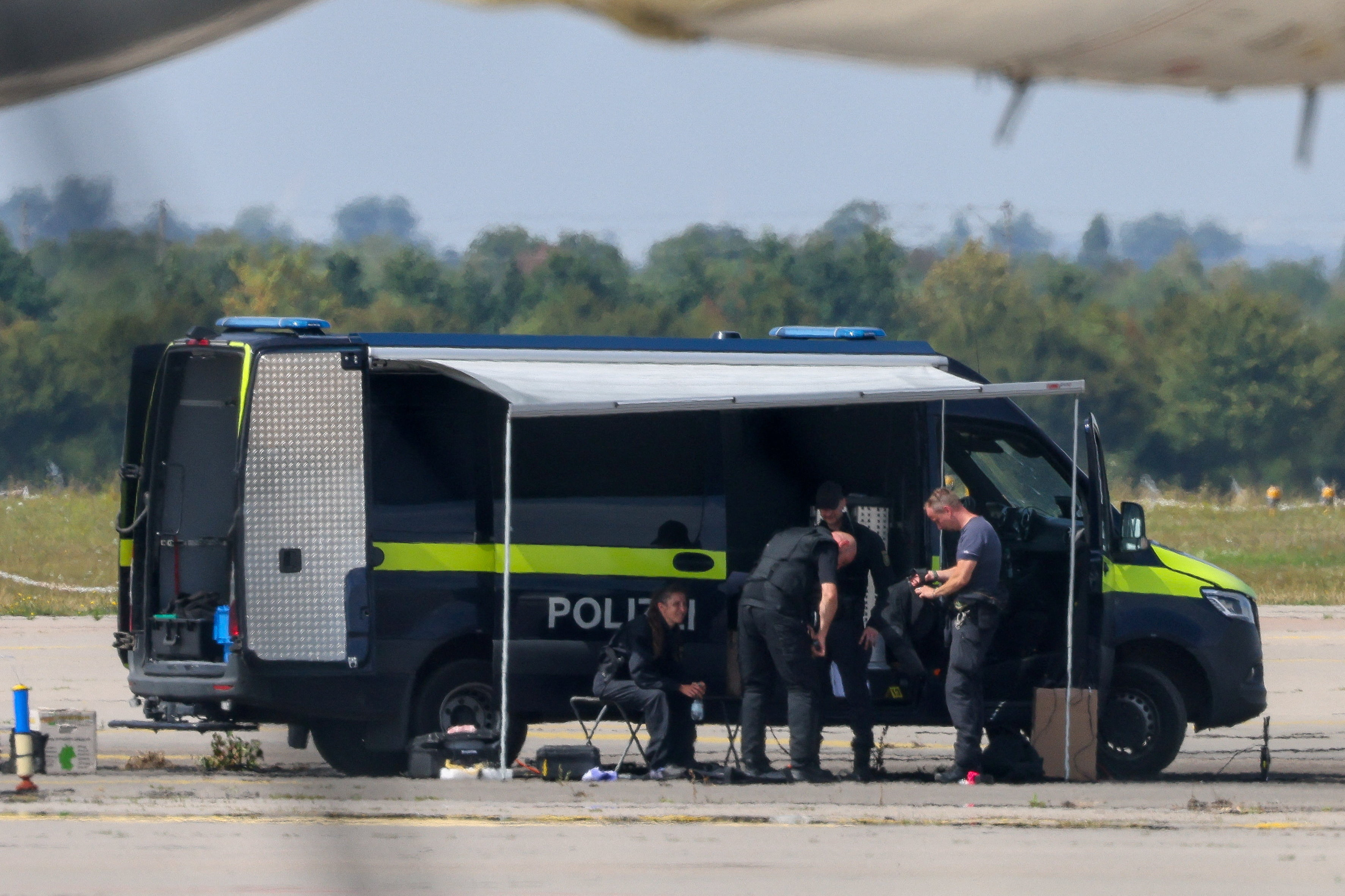 Police near a cargo plane at Leipzig/Halle Airport after a drone incident