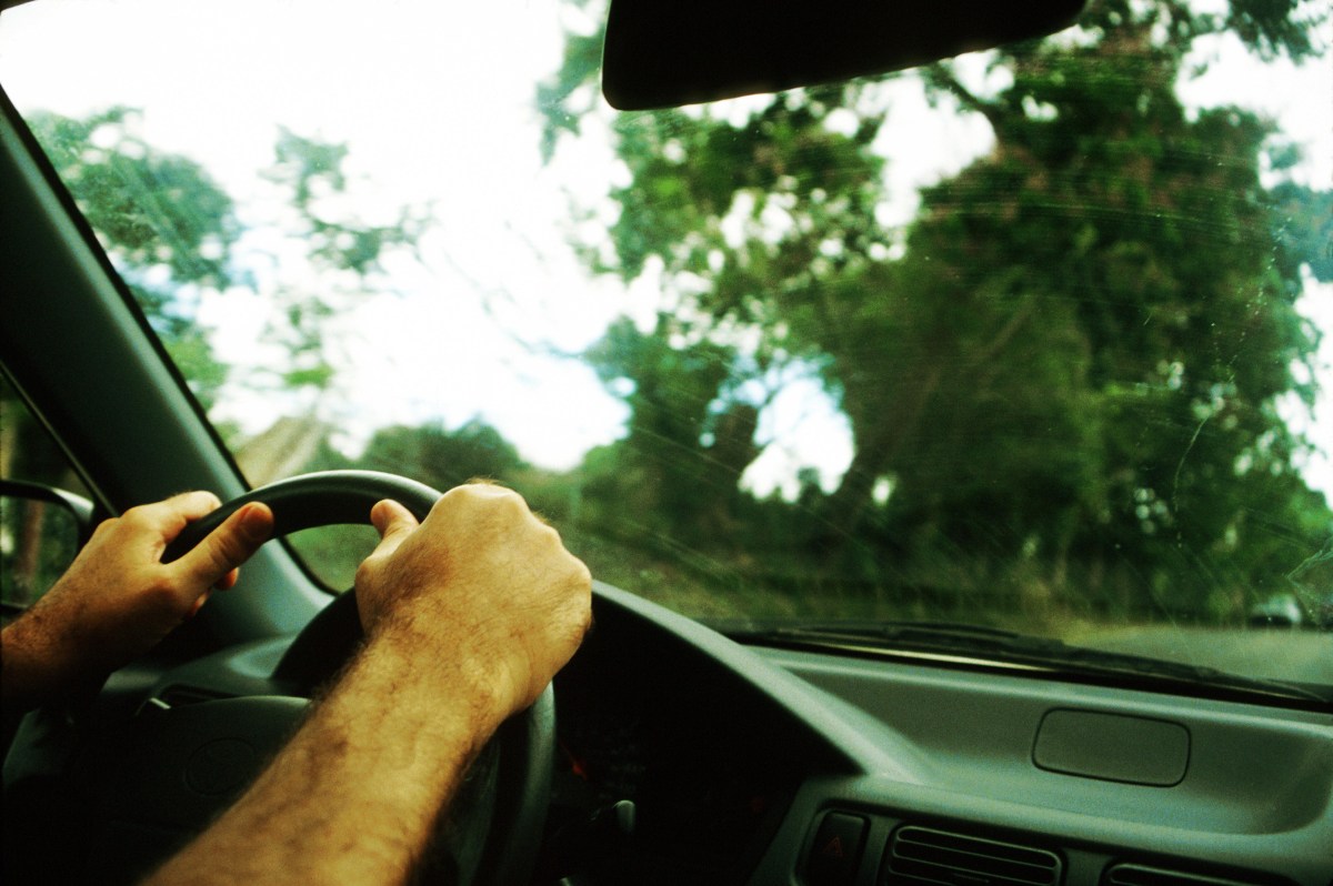 Hands on a steering wheel inside a car